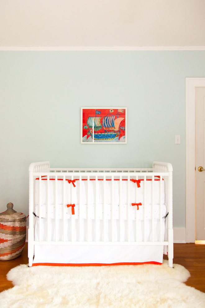 Cette photo montre une chambre de bébé neutre chic de taille moyenne avec un sol marron, un mur gris et parquet foncé.