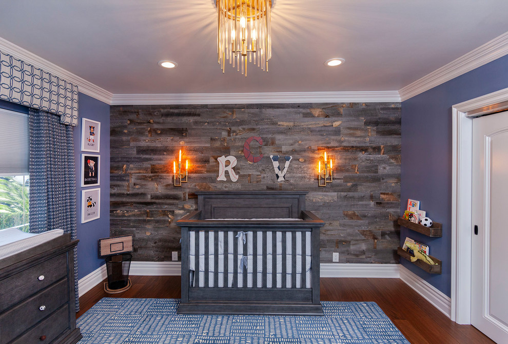 Ejemplo de habitación de bebé niño clásica renovada con paredes azules y suelo de madera oscura