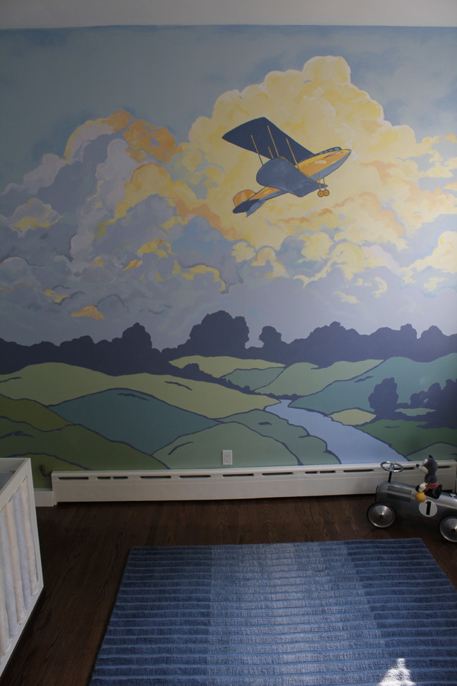Réalisation d'une grande chambre de bébé garçon vintage avec un mur multicolore et parquet foncé.