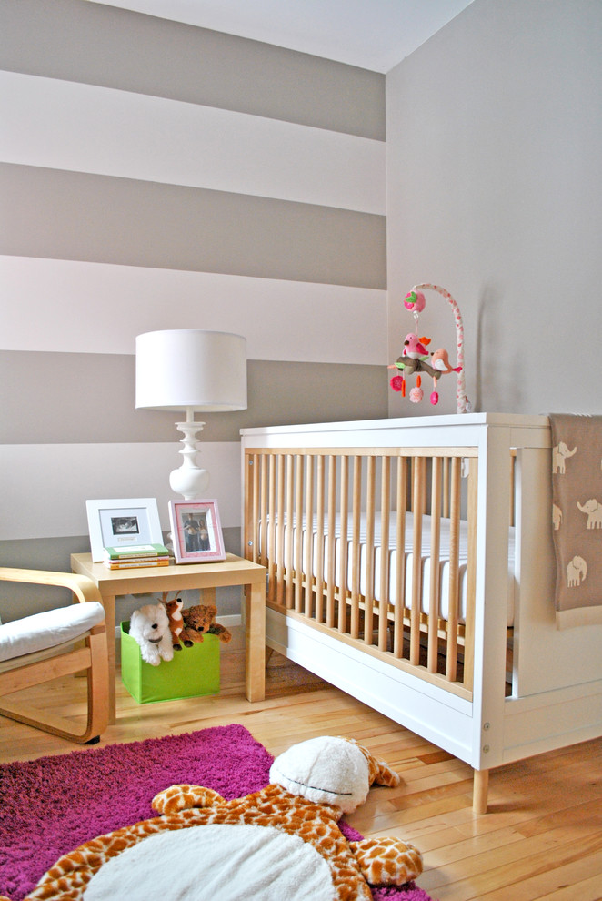 Neutrales Modernes Babyzimmer mit grauer Wandfarbe und braunem Holzboden in Ottawa