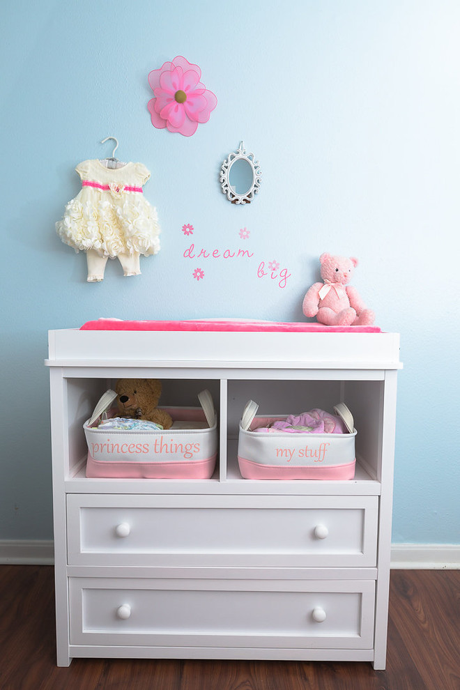 Exemple d'une chambre de bébé fille romantique avec un mur bleu.