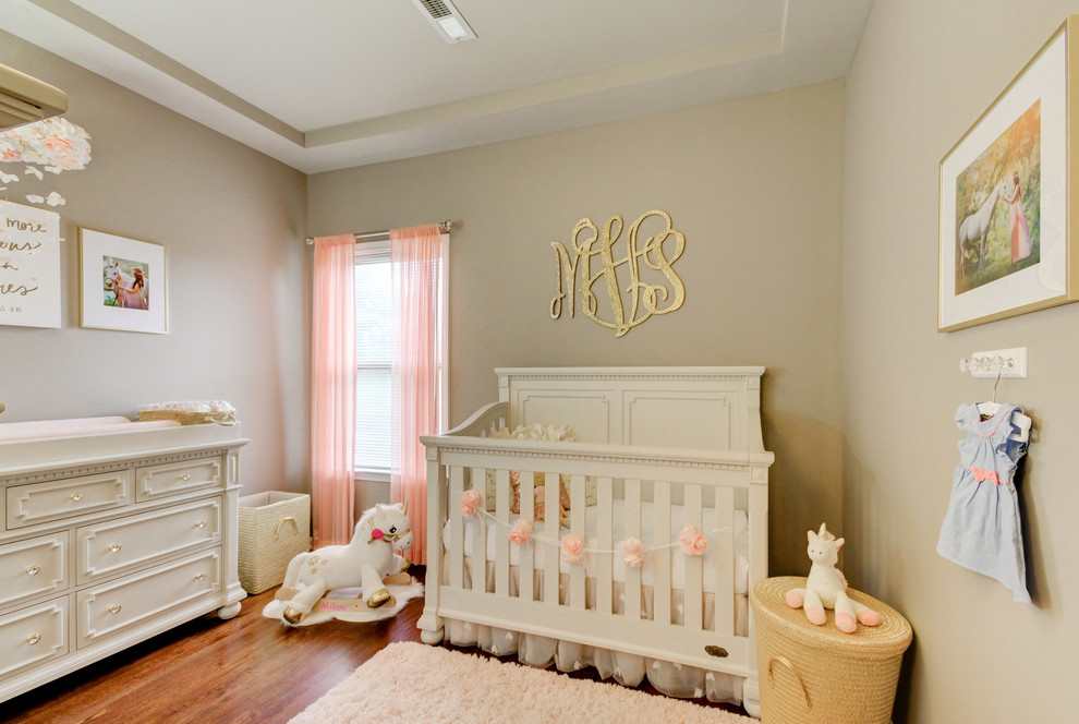 Foto de habitación de bebé niña romántica pequeña con paredes grises, suelo de madera en tonos medios y suelo marrón