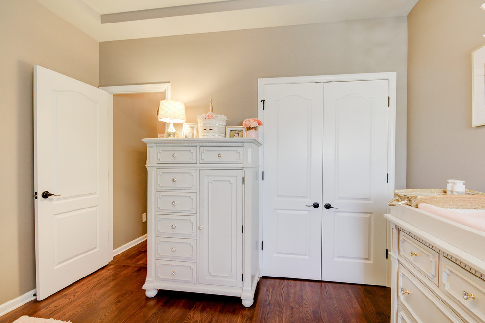 Cette image montre une petite chambre de bébé fille style shabby chic avec un mur gris, un sol en bois brun et un sol marron.