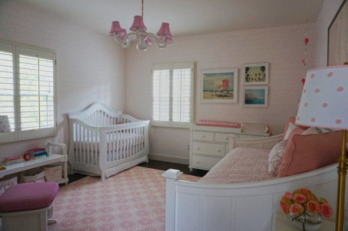 Esempio di una cameretta per neonati tradizionale con pareti rosa
