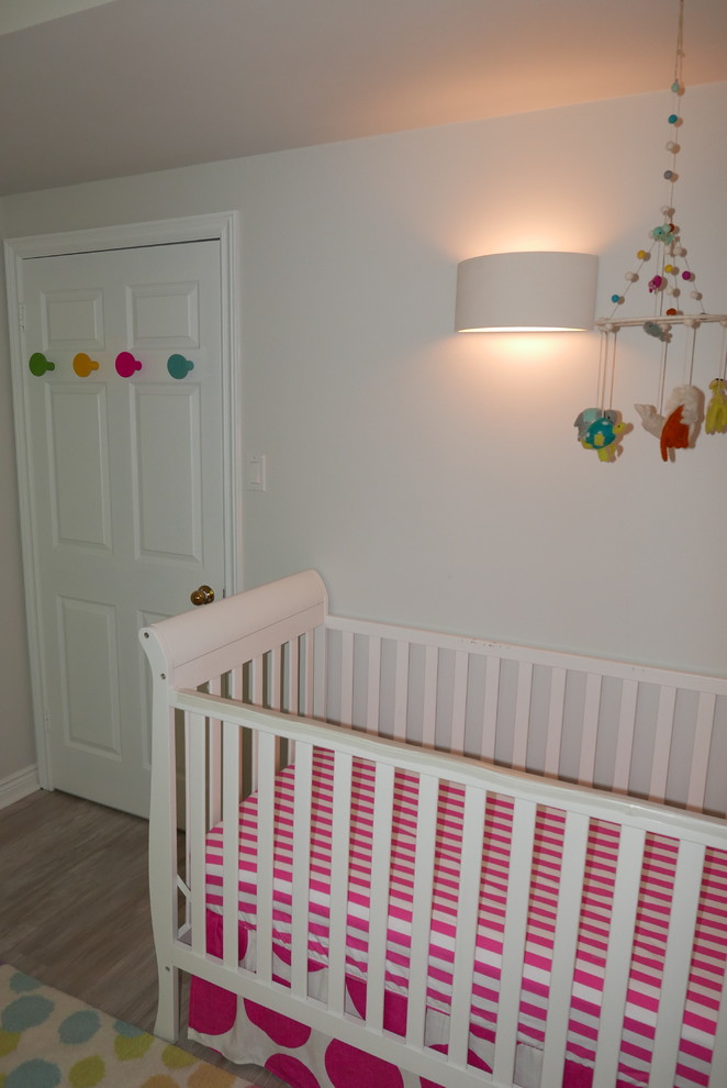 トロントにある中くらいなエクレクティックスタイルのおしゃれな赤ちゃん部屋 (白い壁、磁器タイルの床、女の子用、ベージュの床) の写真