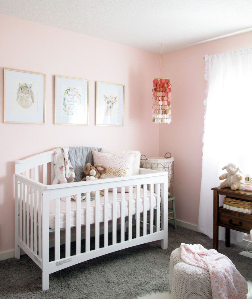 Ejemplo de habitación de bebé niña clásica renovada pequeña con paredes rosas, moqueta y suelo gris