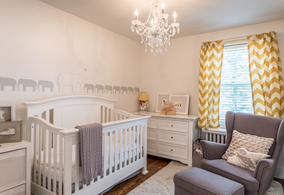 Imagen de habitación de bebé neutra clásica renovada grande con paredes beige, suelo de madera oscura y suelo marrón