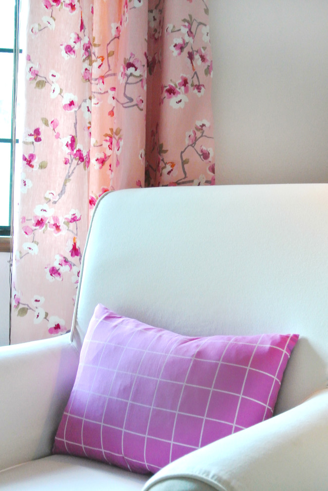 This is an example of a medium sized classic nursery for girls in Other with pink walls and carpet.