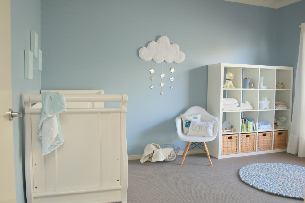 Immagine di una grande cameretta per neonati neutra minimalista con pareti blu e parquet chiaro