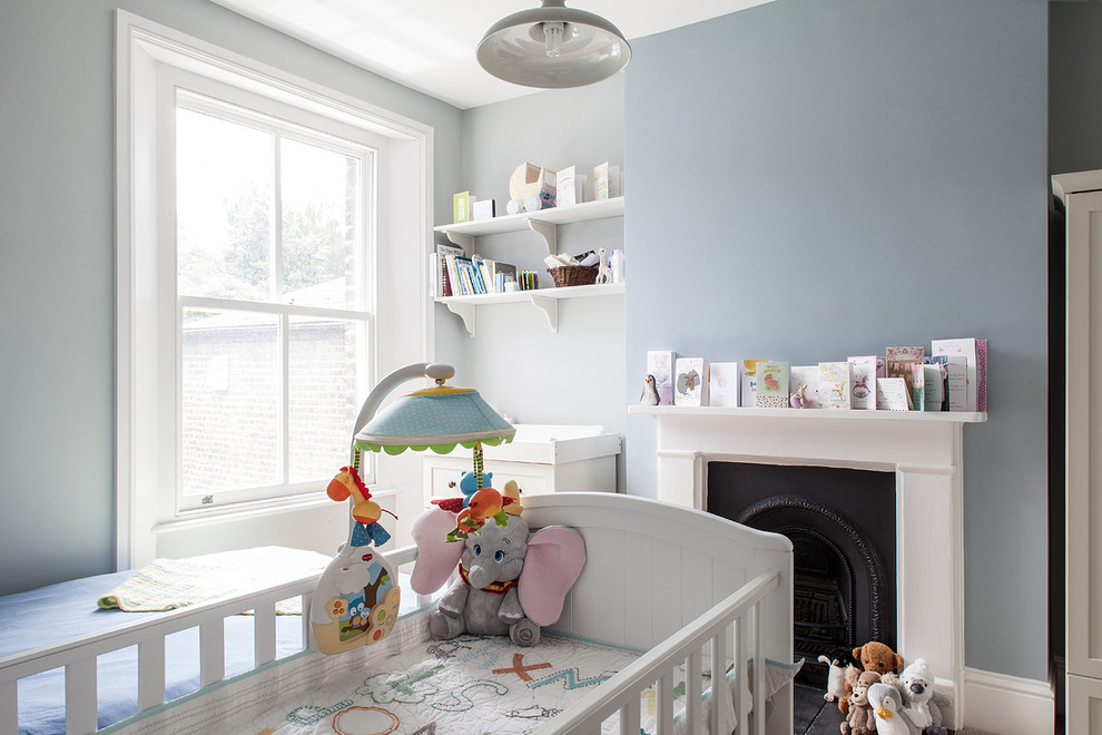 This is an example of a medium sized classic nursery in London with blue walls, carpet and a chimney breast.