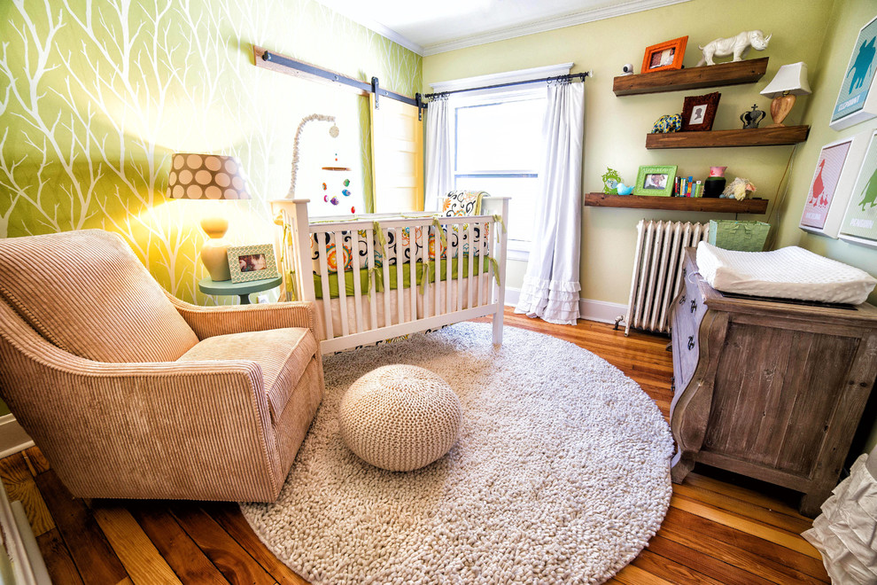 Imagen de habitación de bebé neutra tradicional renovada pequeña con paredes amarillas y suelo de madera en tonos medios