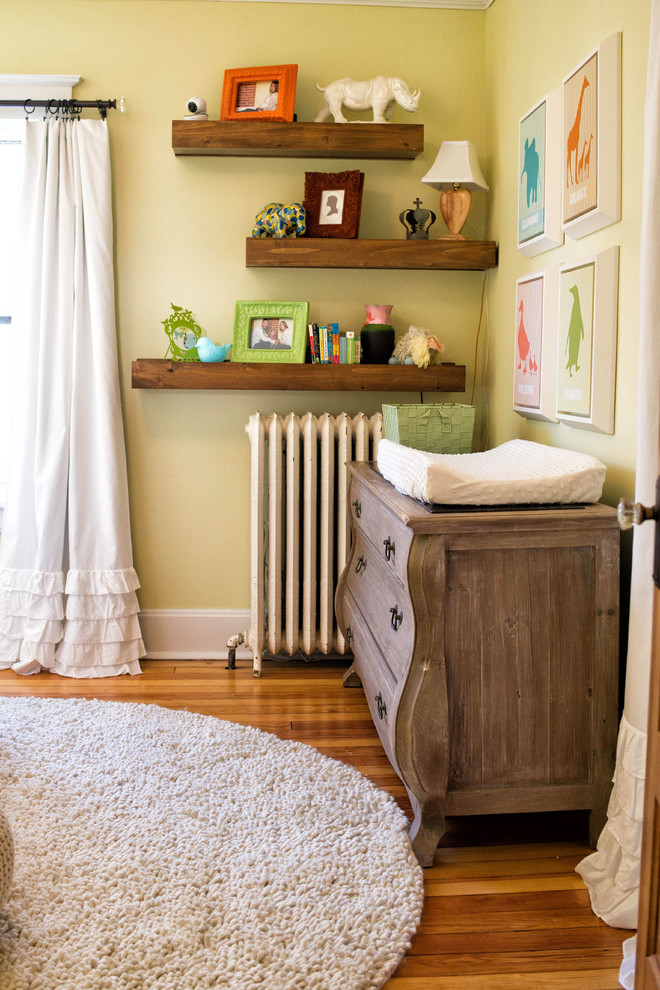 Inspiration for a small transitional gender-neutral medium tone wood floor nursery remodel in Other with yellow walls
