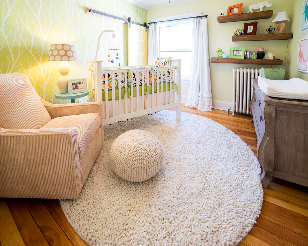 Aménagement d'une petite chambre de bébé neutre classique avec un mur jaune et un sol en bois brun.