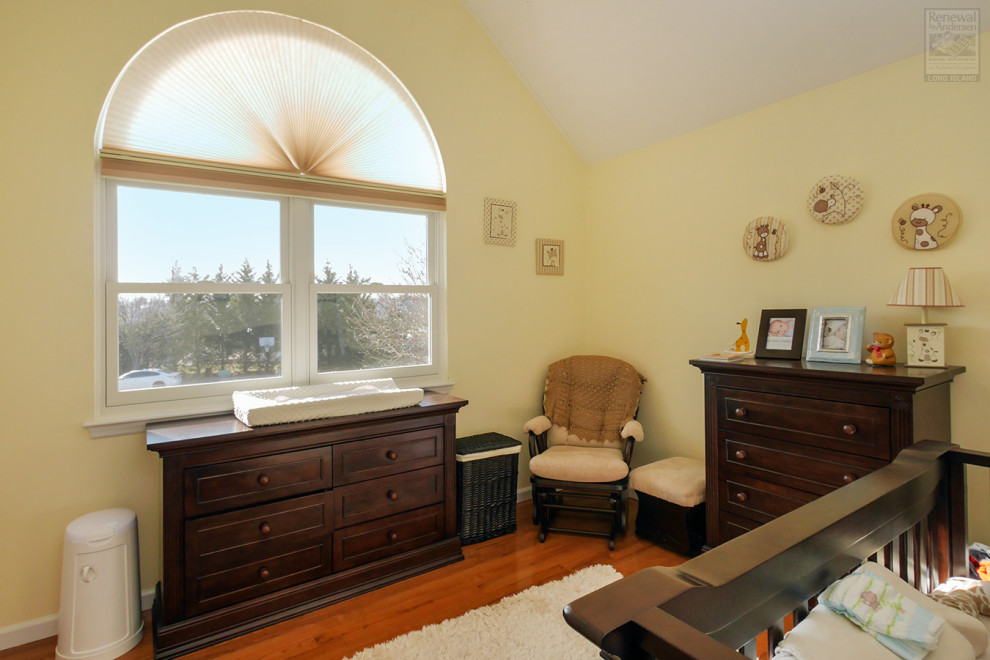 На фото: комната для малыша среднего размера с желтыми стенами, темным паркетным полом и сводчатым потолком для мальчика