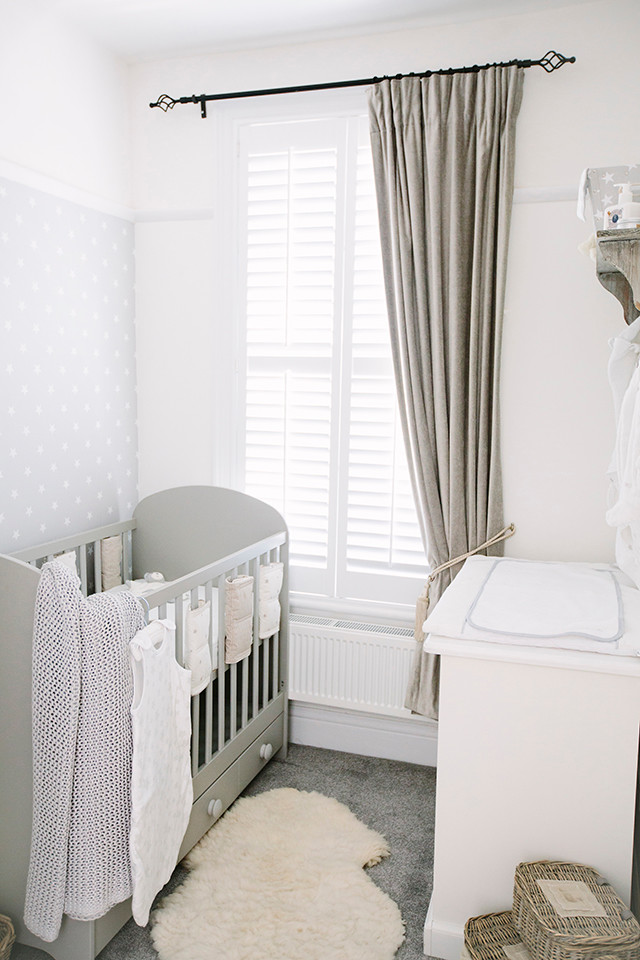Imagen de habitación de bebé neutra contemporánea pequeña con paredes grises y moqueta