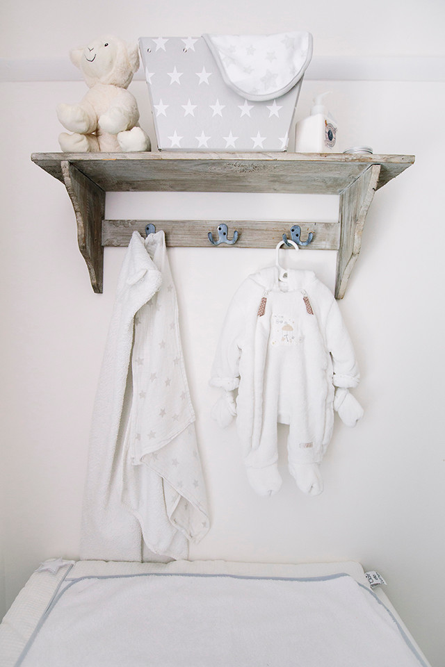 Foto di una piccola cameretta per neonati neutra minimal con pareti grigie e moquette