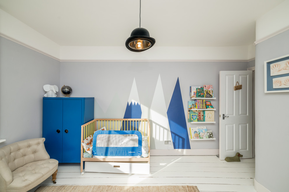 Imagen de habitación de bebé niño actual con paredes grises, suelo de madera pintada y suelo blanco