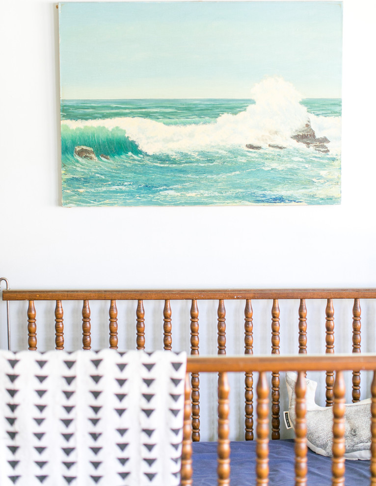 Imagen de habitación de bebé neutra marinera con paredes blancas y suelo de madera oscura