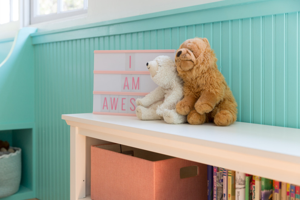Réalisation d'une chambre de bébé neutre design de taille moyenne avec un mur beige et un sol en bois brun.