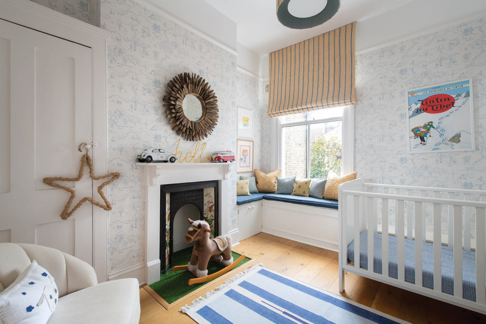 This is an example of a victorian nursery for boys in London with multi-coloured walls, light hardwood flooring and a chimney breast.