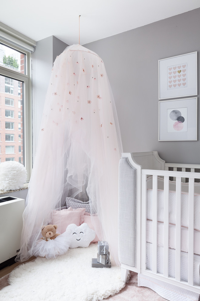 Idée de décoration pour une petite chambre de bébé fille tradition avec un mur gris, moquette et un sol rose.