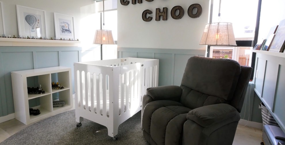 Diseño de habitación de bebé neutra clásica renovada de tamaño medio con paredes blancas, suelo de baldosas de cerámica y suelo gris