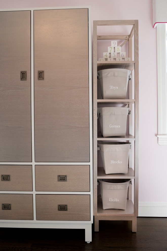 Exemple d'une chambre de bébé fille chic de taille moyenne avec un mur rose et parquet foncé.