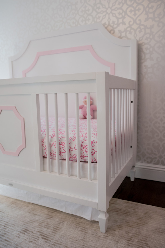 Design ideas for a medium sized traditional nursery for girls in New York with pink walls and dark hardwood flooring.