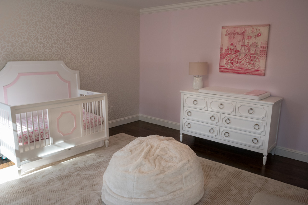 Diseño de habitación de bebé niña clásica renovada de tamaño medio con paredes rosas y suelo de madera oscura