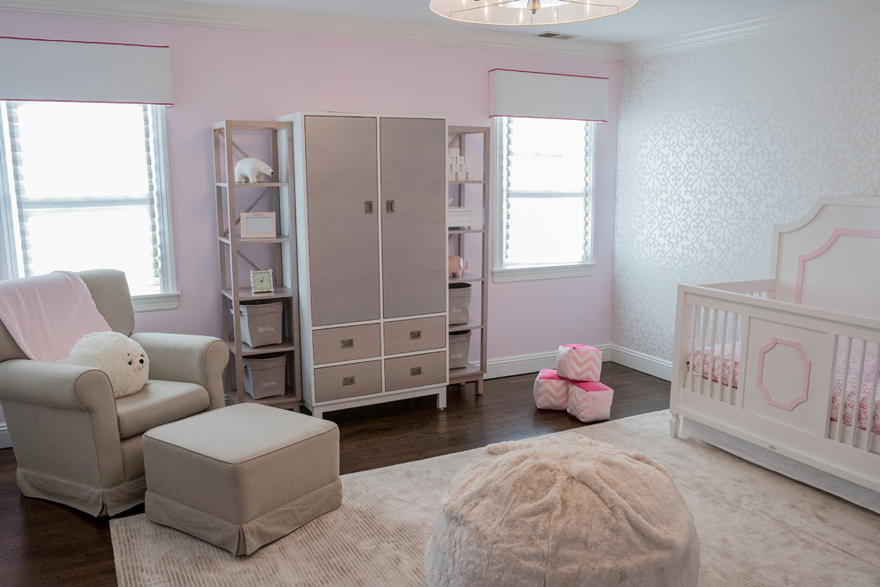 Imagen de habitación de bebé niña tradicional renovada de tamaño medio con paredes rosas y suelo de madera oscura