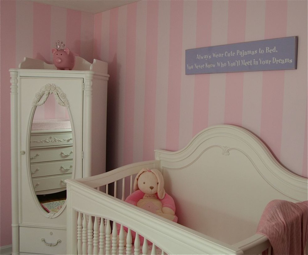 Example of a classic girl nursery design in Cleveland with pink walls
