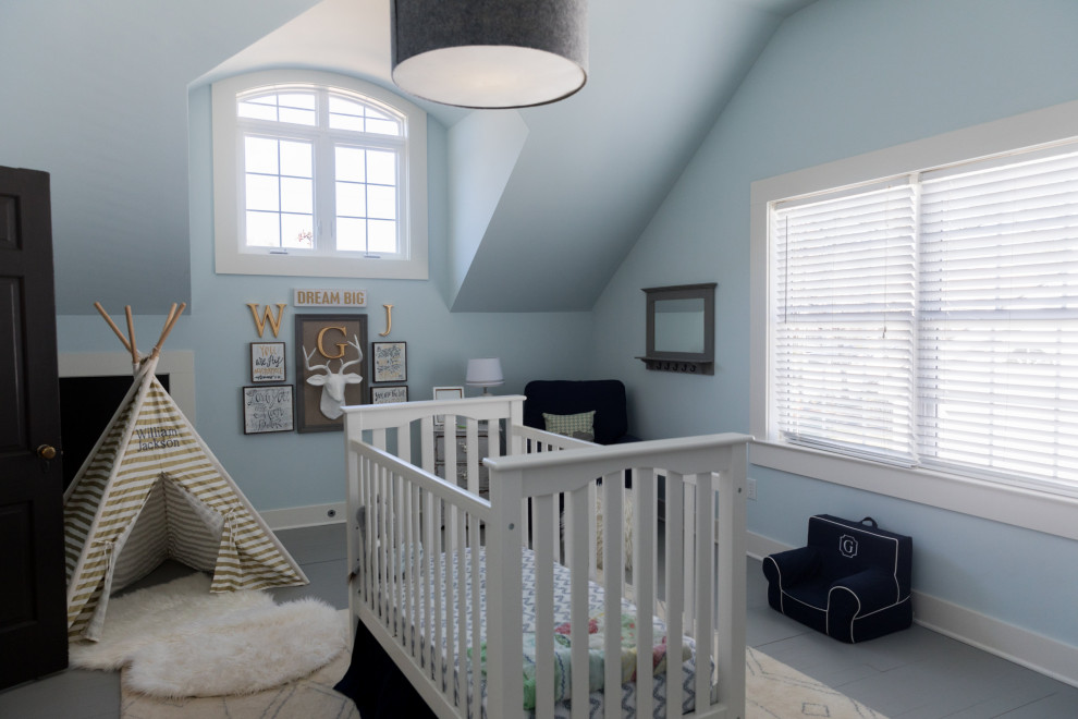 Cette image montre une chambre de bébé garçon traditionnelle avec un mur bleu et un sol gris.