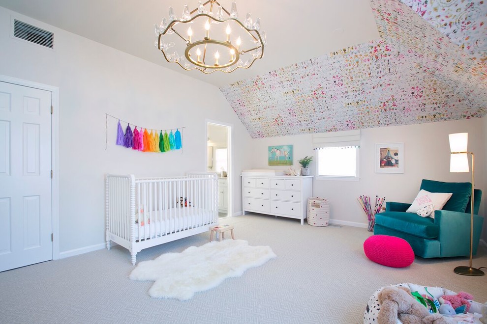 Photo of a large traditional nursery for girls in New York with beige walls, carpet and beige floors.