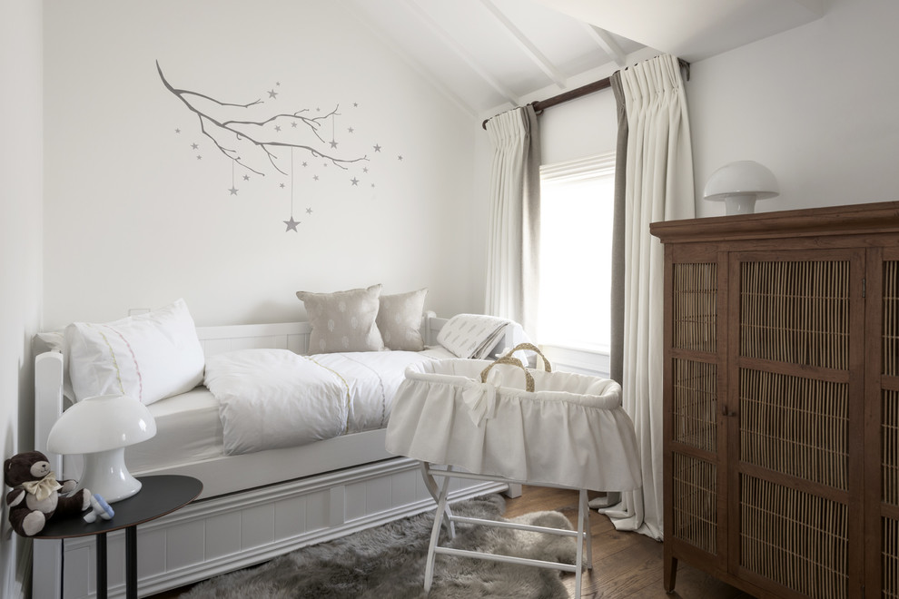 ロンドンにある中くらいなトランジショナルスタイルのおしゃれな赤ちゃん部屋 (白い壁、無垢フローリング、男女兼用、茶色い床) の写真