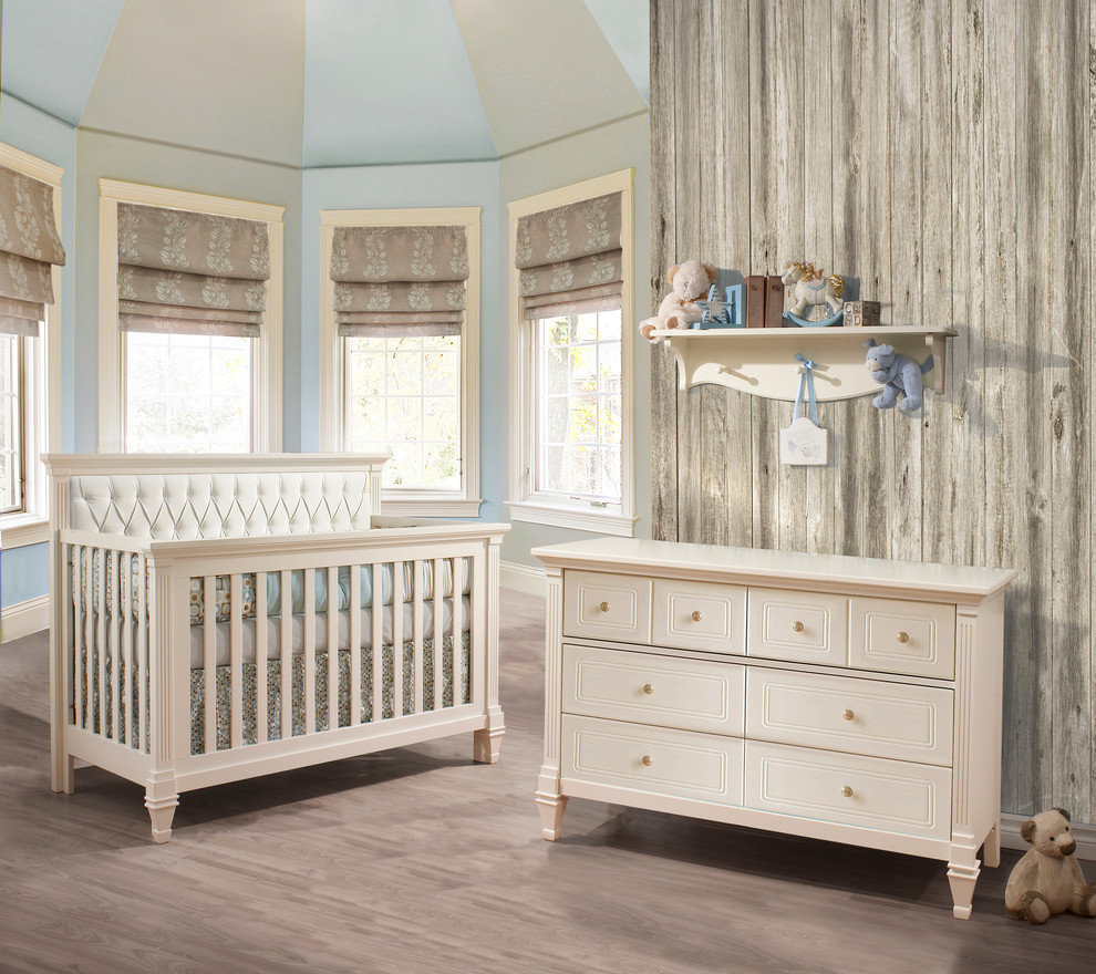 Esempio di una cameretta per neonato design con pareti blu e parquet chiaro