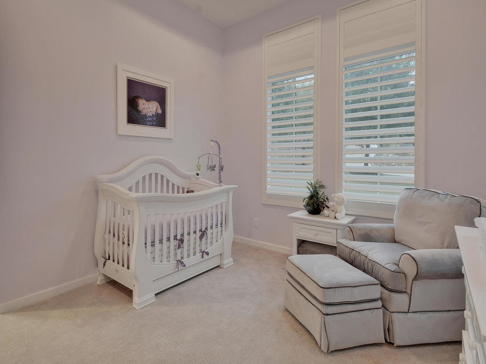 Modelo de habitación de bebé niña actual de tamaño medio con paredes púrpuras, moqueta y suelo beige