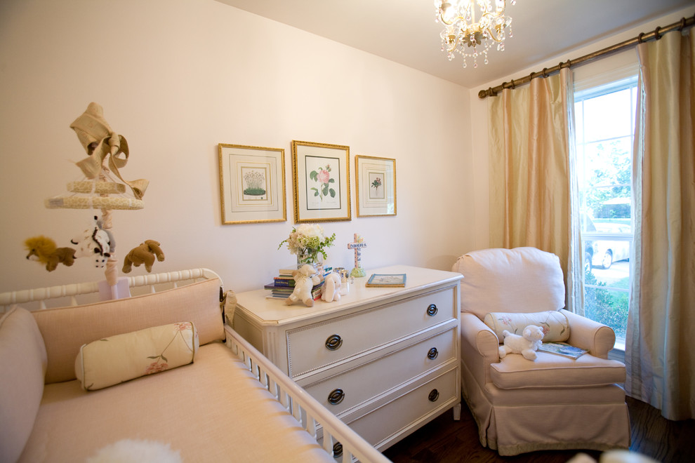 Idées déco pour une chambre de bébé neutre classique de taille moyenne avec un mur blanc et parquet foncé.