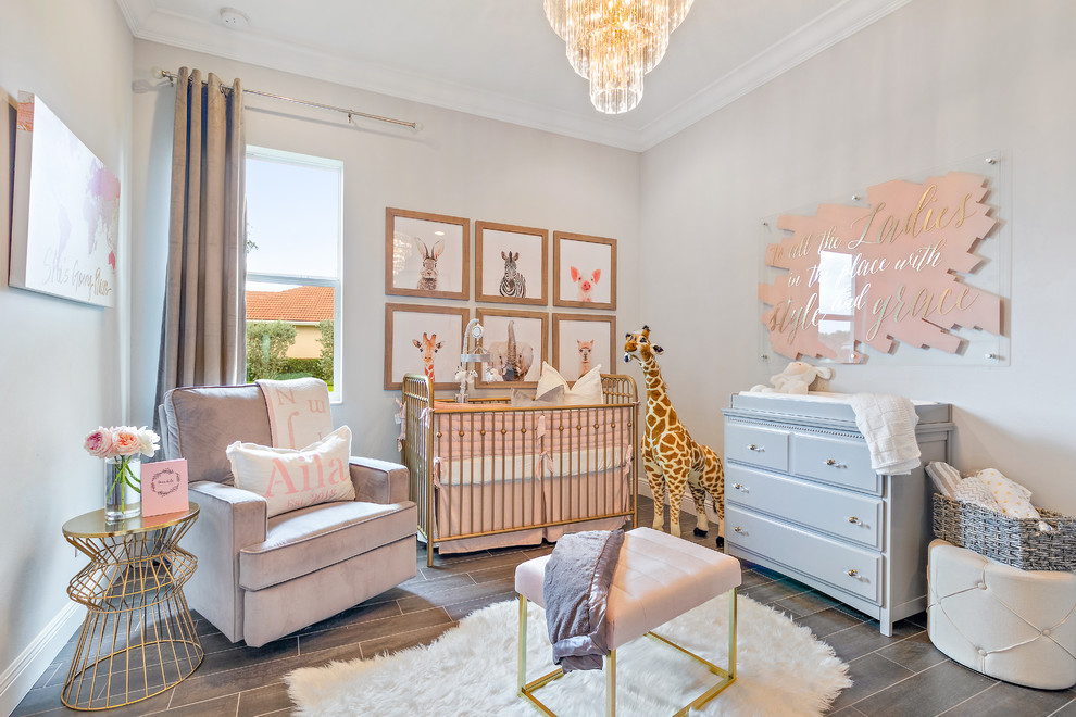 Imagen de habitación de bebé niña moderna de tamaño medio con paredes grises, suelo de baldosas de cerámica y suelo gris