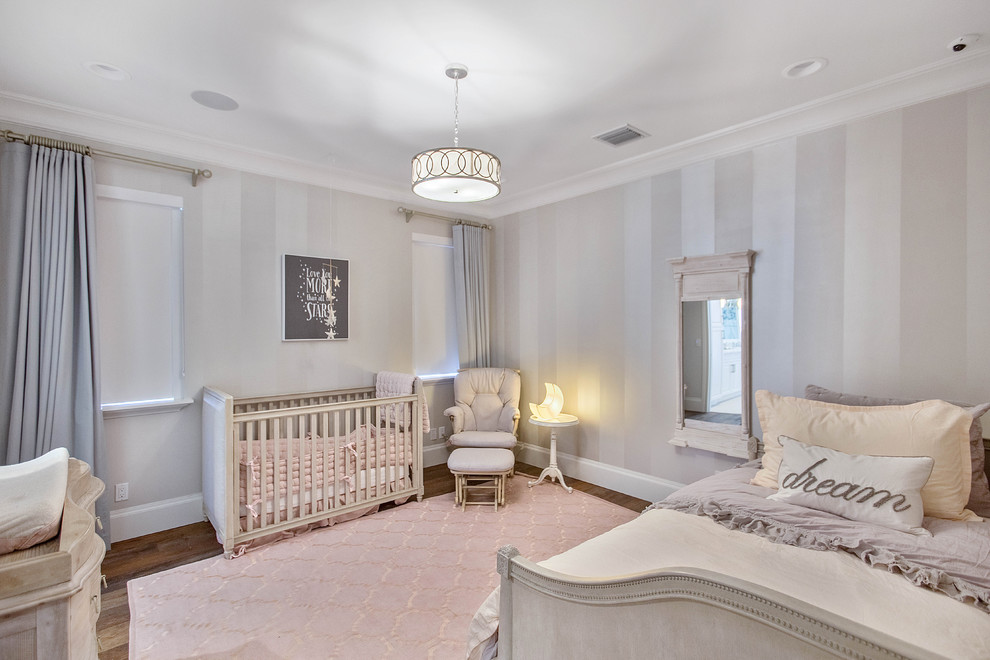 Aménagement d'une chambre de bébé fille classique avec un mur beige, parquet foncé et un sol marron.