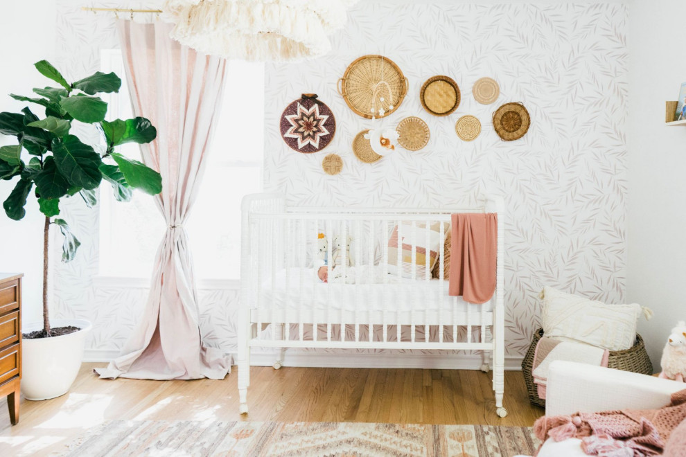 Modelo de habitación de bebé niña campestre de tamaño medio con paredes blancas, suelo de madera clara y suelo marrón