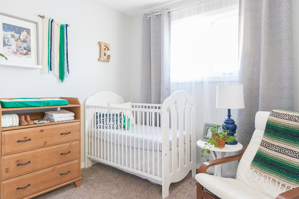 This is an example of a classic gender neutral nursery in Edmonton with white walls, carpet and brown floors.