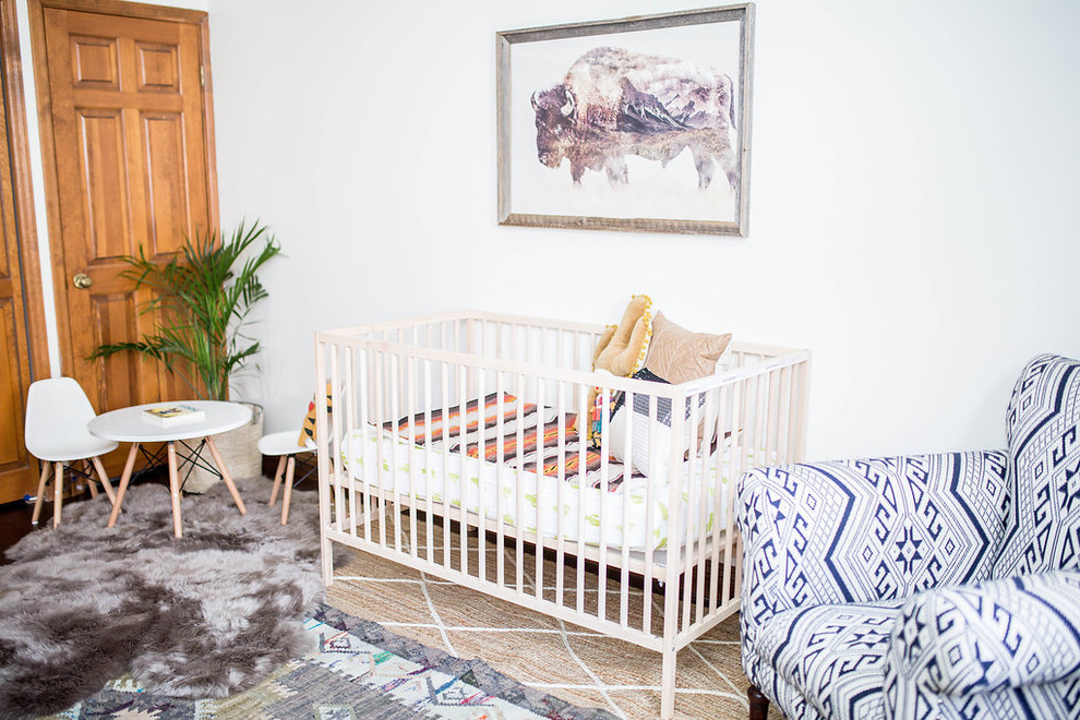 Imagen de habitación de bebé niño de estilo americano de tamaño medio con paredes blancas, suelo de madera oscura y suelo marrón