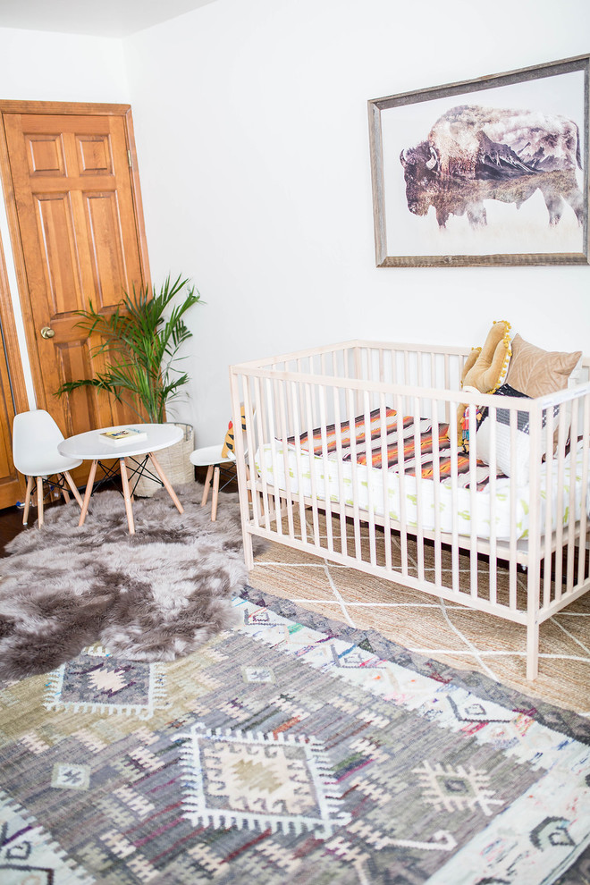 Immagine di una cameretta per neonato american style di medie dimensioni con pareti bianche, parquet scuro e pavimento marrone