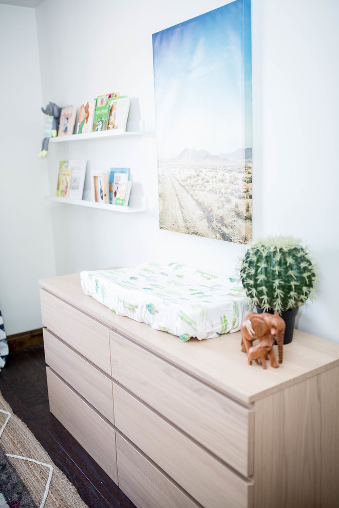 Cette image montre une chambre de bébé garçon sud-ouest américain de taille moyenne avec un mur blanc, parquet foncé et un sol marron.