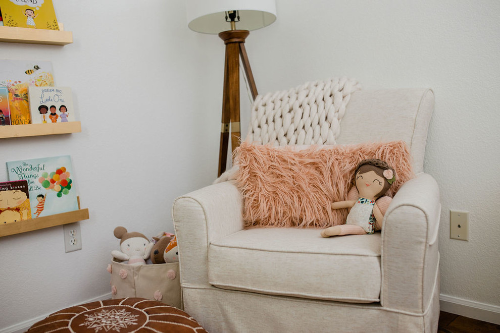 Exemple d'une chambre de bébé fille éclectique de taille moyenne avec un mur blanc, parquet foncé et un sol marron.