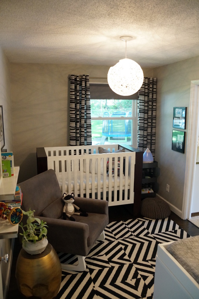 Réalisation d'une petite chambre de bébé neutre minimaliste avec un mur gris et parquet foncé.