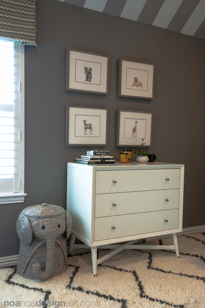Cette image montre une petite chambre de bébé garçon minimaliste avec un mur gris et parquet foncé.