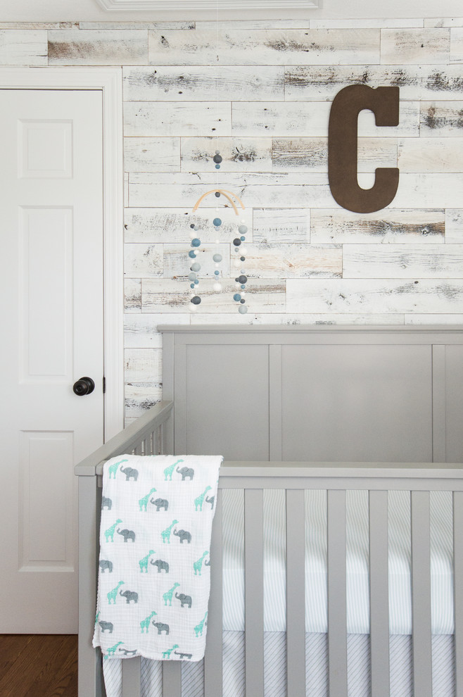 Imagen de habitación de bebé niño industrial de tamaño medio con paredes grises y suelo de madera en tonos medios
