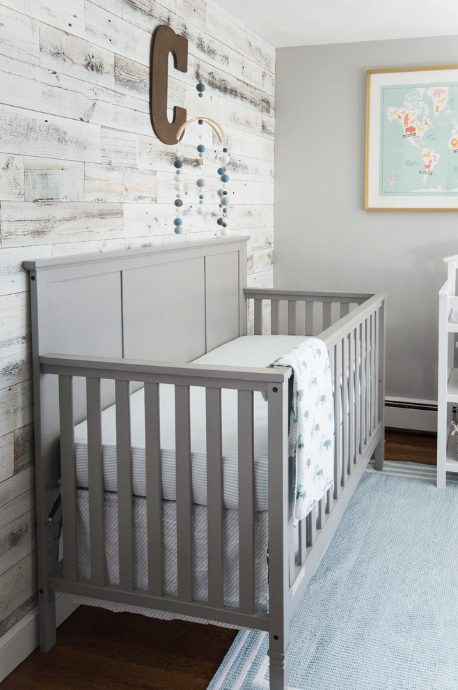 Imagen de habitación de bebé niño urbana de tamaño medio con paredes grises y suelo de madera en tonos medios