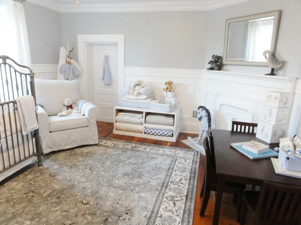 Foto de habitación de bebé neutra tradicional de tamaño medio con paredes grises y suelo de madera en tonos medios
